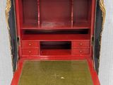 an old black and red desk with a green top