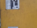 a yellow refrigerator with a sign on the side of it