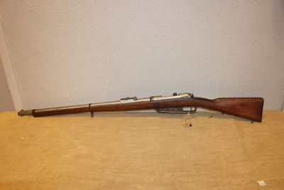 un fusil posé sur une table près d'un mur