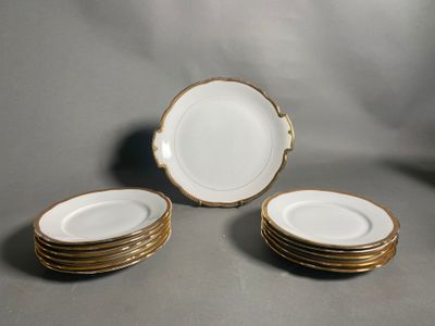 quatre assiettes blanches à bord doré sont empilées les unes sur les autres