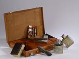 a brown suitcase with tools in it on a white surface