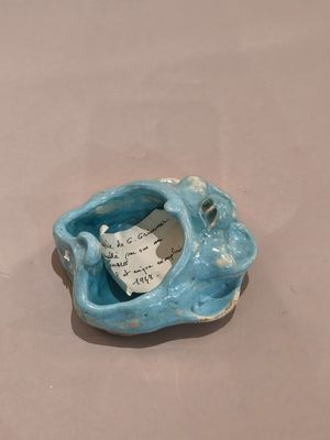 un petit bol bleu contenant un bout de papier