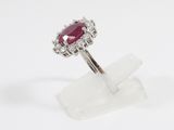 a close up of a diamond and ruby ring on a white background