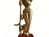statue of a woman holding a staff on a wooden base