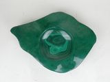 a close up of a green bowl on a white surface