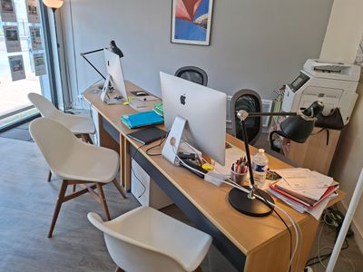 un bureau avec deux ordinateurs et deux chaises dans la pièce