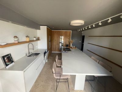 une cuisine avec une table et des chaises au milieu