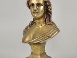 a gold bust of a woman with a hat on her head