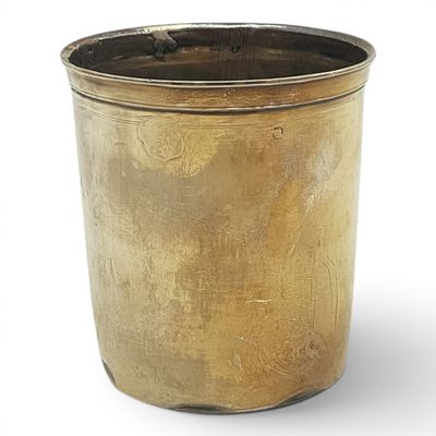 a gold pot that is sitting on a white surface