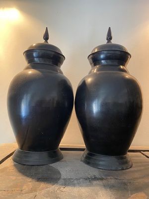deux vases noirs posés sur une table dans une pièce