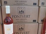 trois bouteilles de vin posées sur une table en bois, à côté de cartons de vin