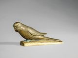une image représentant une figurine en or représentant un oiseau perché sur une branche