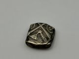 a small silver coin with a design on it