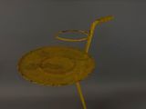 an old yellow chair sitting on top of a wooden table