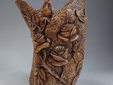 un vase marron orné d'un oiseau et de fleurs