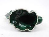 a green vase that is sitting on a white surface