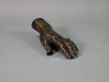 bronze statue of a hand holding something on a table