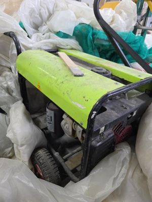 un générateur vert et noir posé au milieu d'un tas de sacs