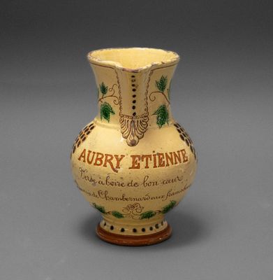 a yellow vase with writing on it sitting on a table