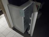 un petit réfrigérateur dont la porte est ouverte dans une cuisine