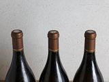 three bottles of wine sitting on a table next to each other