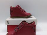two pairs of red shoes sitting on top of a white box