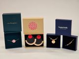 trois boîtes de bijoux posées sur une surface blanche