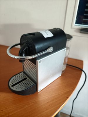 a coffee machine on a table with a cup on it