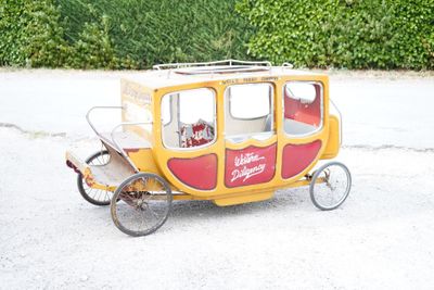 a small yellow and red carriage on the street