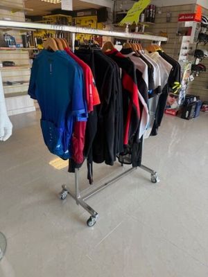 beaucoup de vêtements suspendus à une étagère dans un magasin