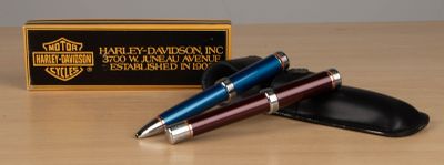 two pens and a wallet on a table