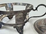 a silver tea pot and a silver plate on a table