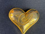 une pierre jaune en forme de cœur, ornée d'un motif en spirale