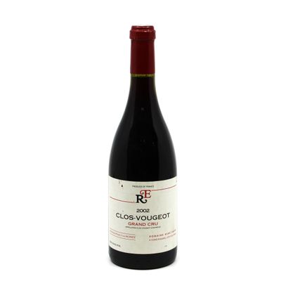 the bottle of red wine is sitting on a white surface