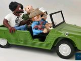 a figurine of three people riding in a green jeep