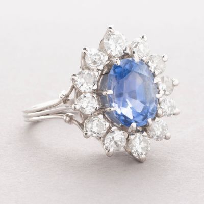 gros plan d'une bague avec un saphir bleu entouré de diamants blancs
