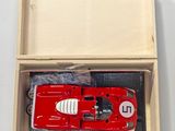 une maquette rouge d'une voiture de course dans une boîte en bois