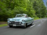 a car that is driving down the road with trees in the background