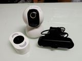 a white camera and a remote control on a table