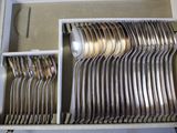 a lot of silver spoons and forks in a box