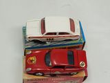 two toy cars sitting on top of each other on a table