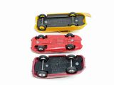 three toy cars sitting next to each other on a white surface