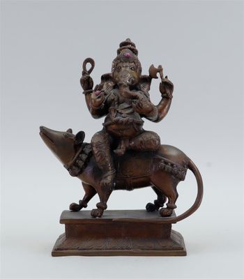 bronze statue of a man riding on top of a cow