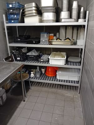 de nombreuses casseroles et poêles sur les étagères de la cuisine