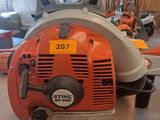 an orange and white chainsaw sitting on top of a table in a room