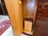 a wooden cabinet with a trash can inside of it
