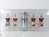 trois flacons de parfum dans une boîte transparente posée sur une table