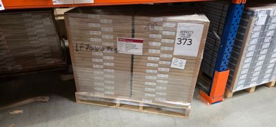 une grande pile de cartons posée sur une palette dans un magasin