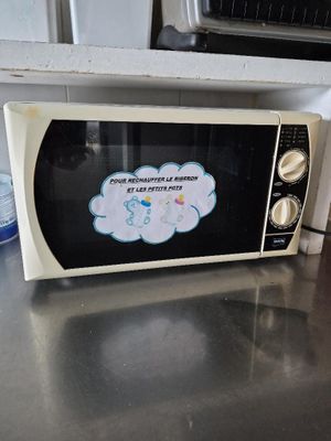 un micro-ondes posé sur le plan de travail de la cuisine