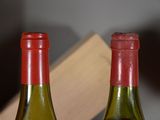two bottles of wine sitting next to each other on a table